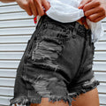 Person in schwarzen Jeansshorts mit farbenfrohem Taschenmuster vor neutralem Hintergrund