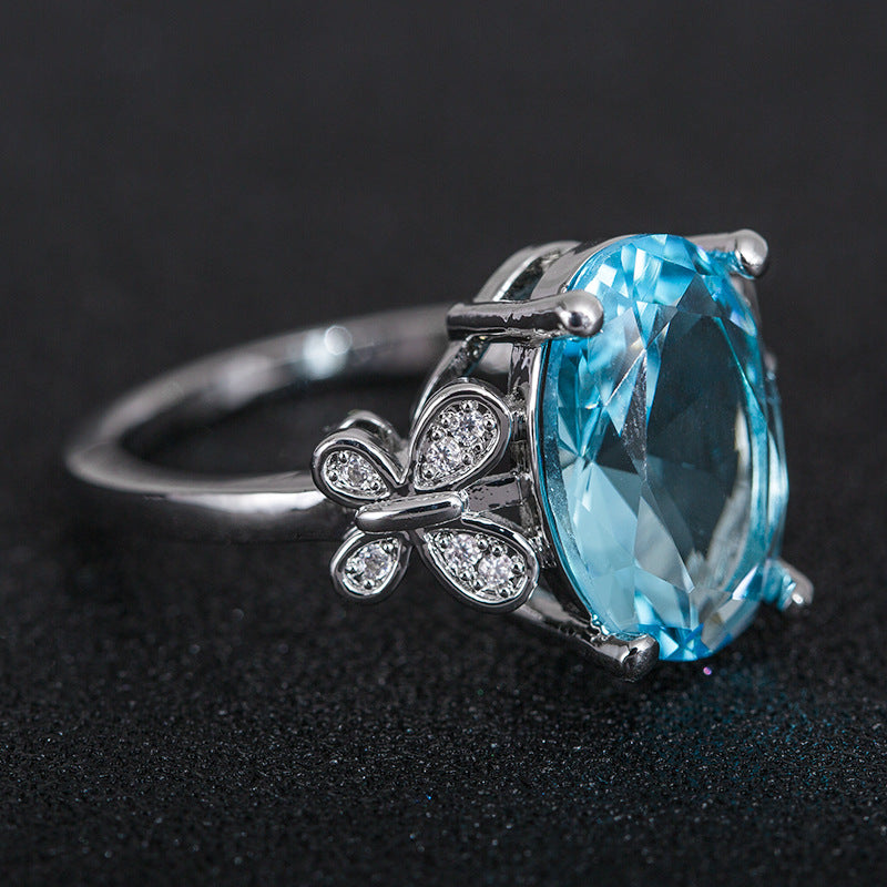 Eleganter Damenring mit großem blauem Zirkon & Schleifen-Design
